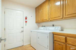 Laundry room with cabinet space and washer and clothes dryer
