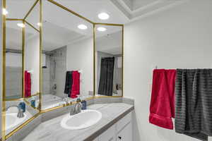 Full bath featuring vanity, shower / tub combo, a textured wall, and recessed lighting