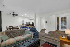Living room with wood finished floors, a ceiling fan, and recessed lighting