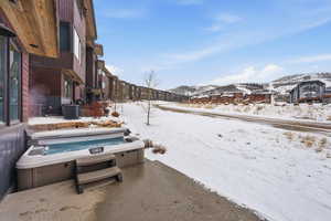 Snowy yard with a mountain view and a patio area