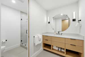 Bathroom with vanity, a stall shower, light tile patterned floors, and recessed lighting