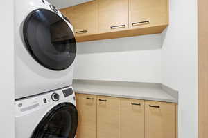 Laundry area with cabinet space and stacked washer / dryer