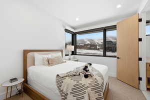 Bedroom with a mountain view, light carpet, and recessed lighting