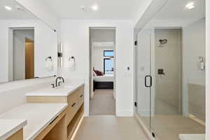Ensuite bathroom featuring vanity, a shower stall, light colored carpet, light tile patterned flooring, and recessed lighting
