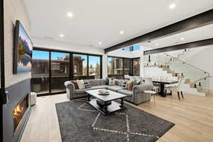 Living area featuring light wood-type flooring, recessed lighting, and a glass covered fireplace