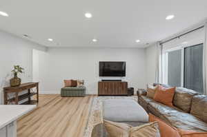 Living area with recessed lighting and light wood-type flooring