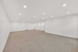 Unfurnished room with light colored carpet and recessed lighting