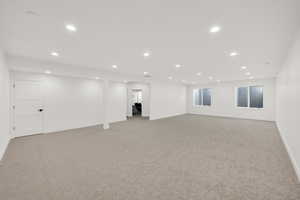 Finished basement with recessed lighting and light colored carpet