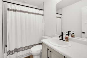 Full bath featuring vanity and curtained shower