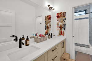 Full bathroom with double vanity and shower / tub combo with curtain