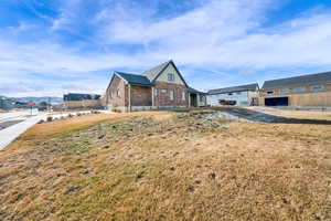 View of front of house featuring brick siding and board and batten siding