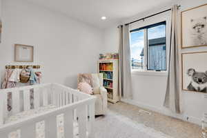 Bedroom with a crib, carpet flooring, and recessed lighting
