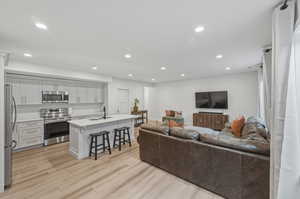 Living area featuring light wood-style floors and recessed lighting