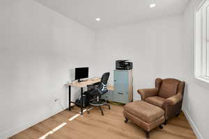 Office area featuring light wood-style flooring and recessed lighting