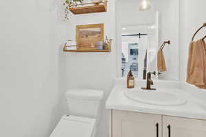 Half bathroom featuring vanity and toilet