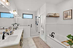 Bathroom featuring double vanity, a garden tub, a shower stall, recessed lighting, and light tile patterned floors