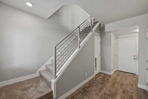 Staircase with baseboards and wood finished floors
