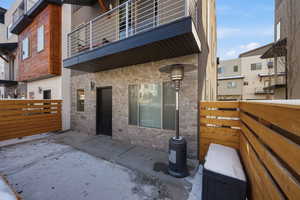 Entrance to property featuring stone siding and a patio