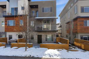 Snow covered building featuring a view of apartment building / complex