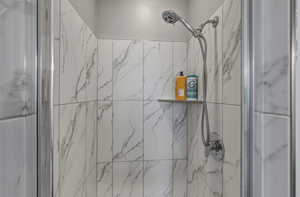 Bathroom featuring a marble finish shower