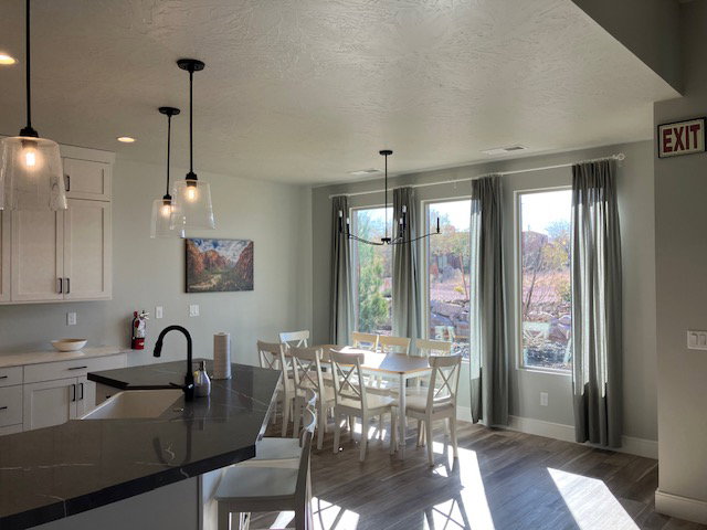 Dining area featuring plenty of natural light, dark wood-style flooring, a textured ceiling, and a chandelier