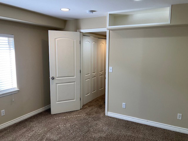 Unfurnished bedroom with dark carpet, a closet, and recessed lighting