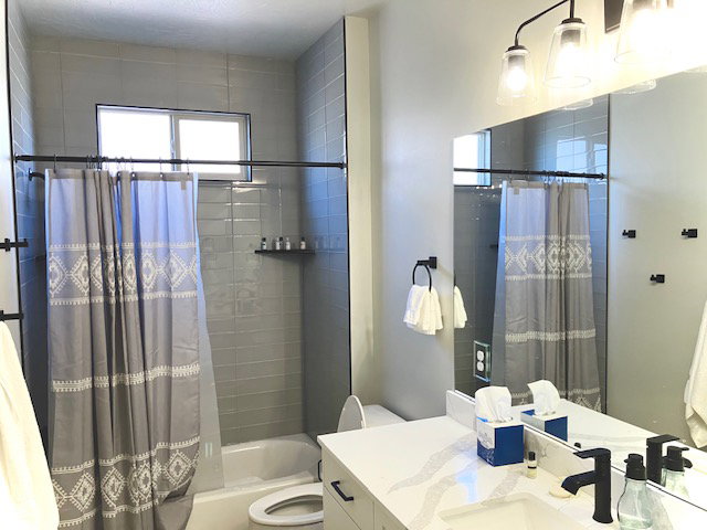 Bathroom featuring shower / bathtub combination with curtain and vanity