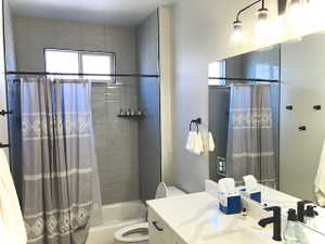 Bathroom featuring shower / bathtub combination with curtain and vanity
