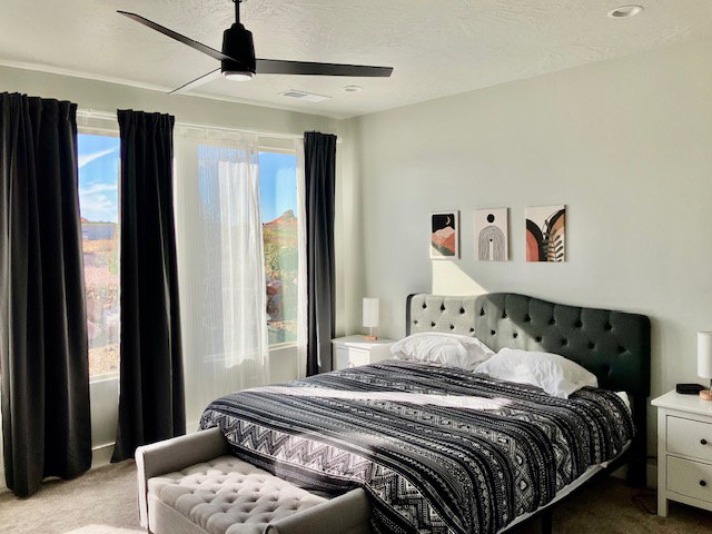 Carpeted bedroom featuring a ceiling fan