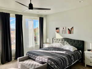 Carpeted bedroom featuring a ceiling fan
