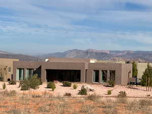 Back of house featuring a mountain view, stucco siding, and a patio area
