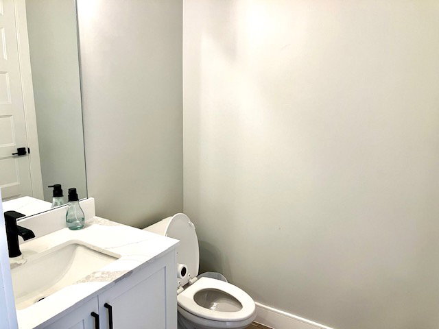 Half bathroom featuring vanity and toilet