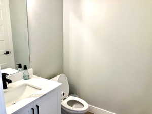 Half bathroom featuring vanity and toilet