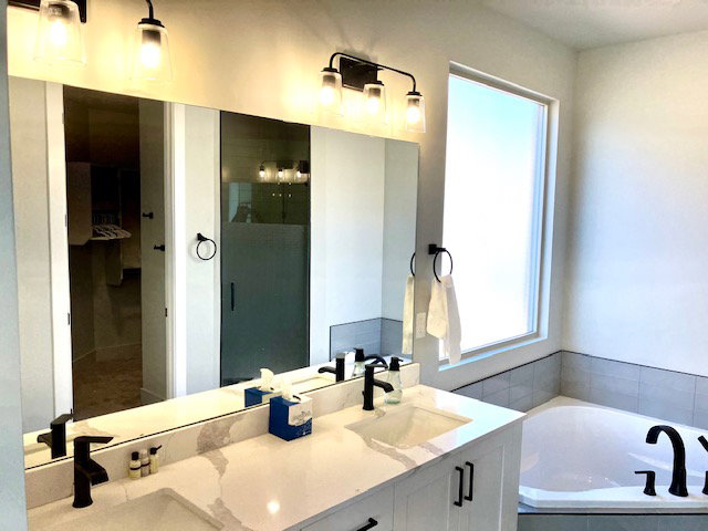 Bathroom with double vanity, a bath, and a stall shower