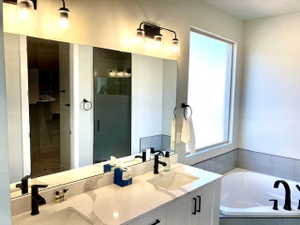 Bathroom with double vanity, a bath, and a stall shower