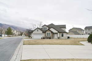 Craftsman inspired home featuring a residential view, stone siding, driveway, and stucco siding
