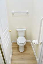 Bathroom featuring toilet and light wood finished floors