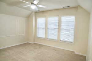 Master bedroom featuring lofted ceiling, light colored carpet, and ceiling fan
