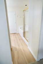 Master bathroom with light wood-style flooring and baseboards