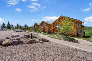 View of front facade with log exterior, a metal roof, and a residential view