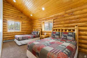 Carpeted bedroom featuring recessed lighting, log walls, baseboard heating, and a vaulted wood ceiling
