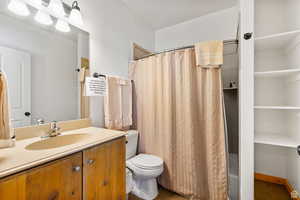 Bathroom with vanity, a shower with shower curtain, and dark tile patterned flooring
