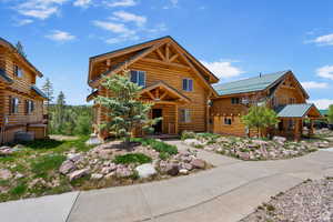 Log-style house with log siding and a metal roof