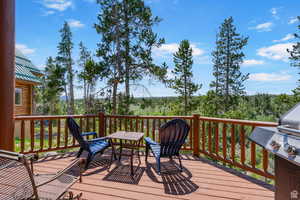 Wooden terrace featuring a grill