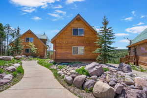 Rear view of house with log siding and a metal roof