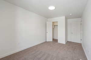 Unfurnished bedroom featuring light colored carpet and a closet