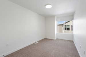 Empty room with light carpet and baseboards