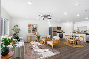 Living room with ceiling fan, dark wood-type flooring, and recessed lighting