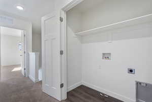 Laundry area with hookup for a washing machine, hookup for an electric dryer, and dark wood-style flooring