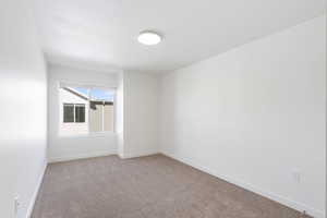 Empty room featuring light carpet and baseboards